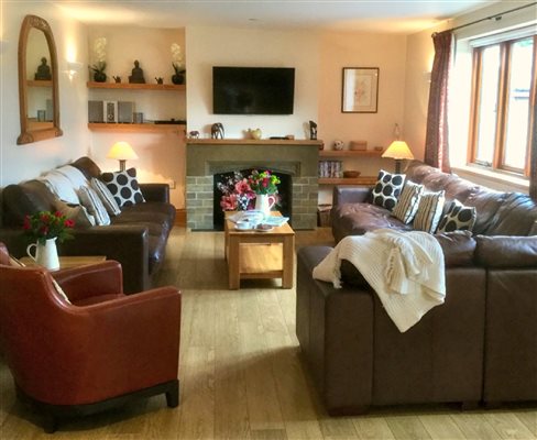 large spacious sitting room with comfy sofa and chairs
